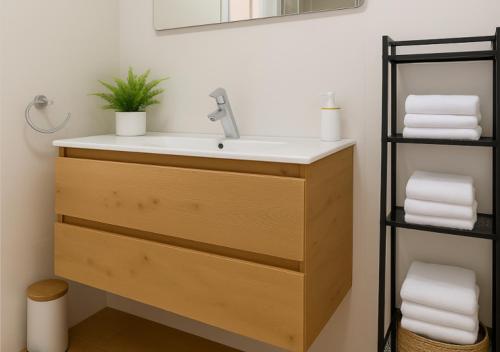 Un baño con lavabo y estante con toallas. en Granada Eye, en Granada