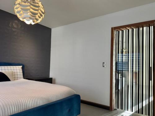 a bedroom with a bed and a chandelier at Aqua Tower 3BR-3BA Beachfront Condo in Playas de Tijuana in Tijuana