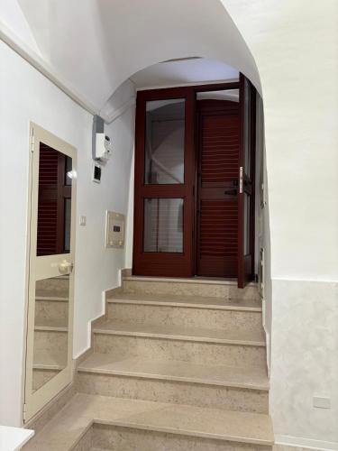 a hallway with a wooden door and stairs at Room 416 - Affitti Brevi Italia in Monte SantʼAngelo