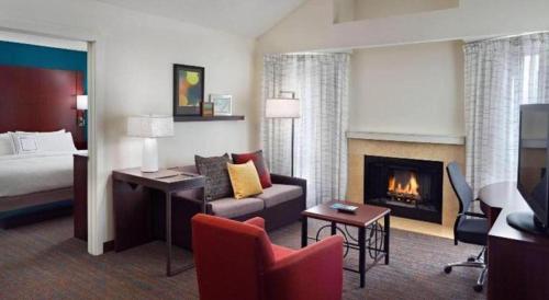 アトランタにあるResidence Inn Atlanta Airport North/Virginia Avenueのベッドと暖炉のあるホテルの部屋