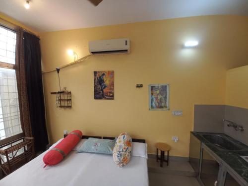a bedroom with a white bed with red pillows at Devi music ashram in Rishīkesh