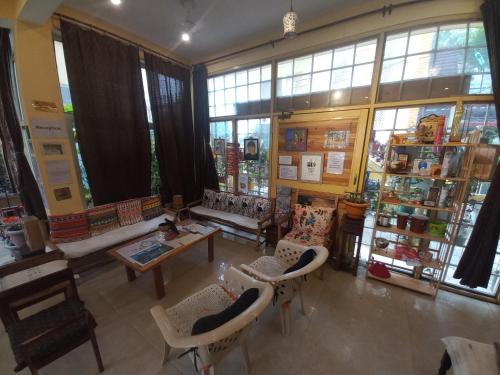 a large room with chairs and a table and windows at Devi music ashram in Rishīkesh