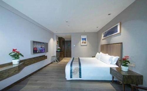 a bedroom with a large white bed and a table at Landmark Hotel in Zhuhai