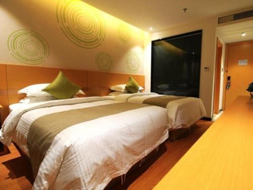 two beds in a hotel room with a large window at GreenTree Inn Fuzhou Gulou District West Xierhuan Road Zuohai Park in Fuzhou