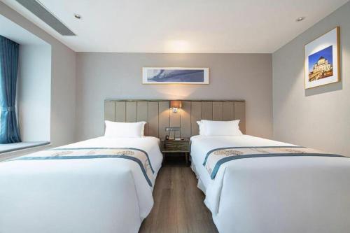 two beds sitting next to each other in a room at Landmark Hotel in Zhuhai