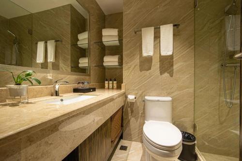 a bathroom with a toilet and a sink at Landmark Hotel in Zhuhai