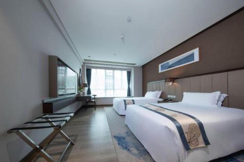 a hotel room with two beds and a window at Landmark Hotel in Zhuhai