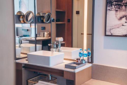 a bathroom with two sinks and a mirror at Wanda JIN Baise in Baise