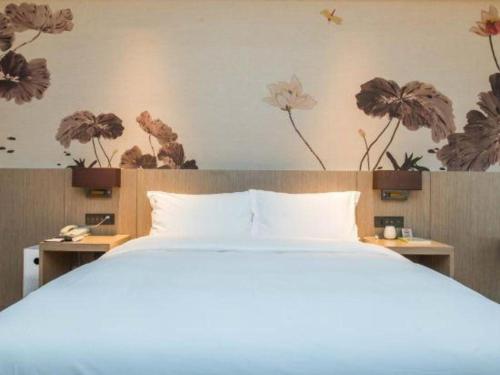 a bedroom with a bed and flowers on the wall at GRACE Select Hotel (Kunshan Huaqiao International Convention Center) in Suzhou