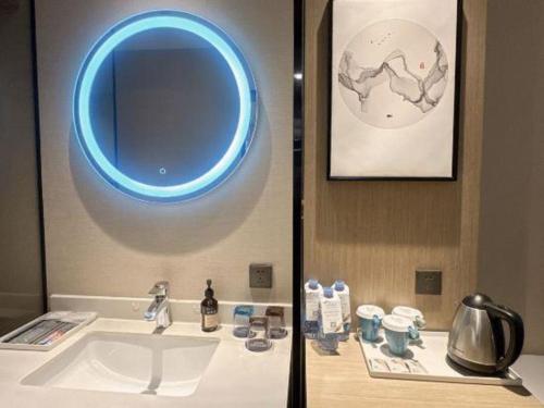 a bathroom with a sink with a blue light above it at GRACE Select Hotel (Kunshan Huaqiao International Convention Center) in Suzhou