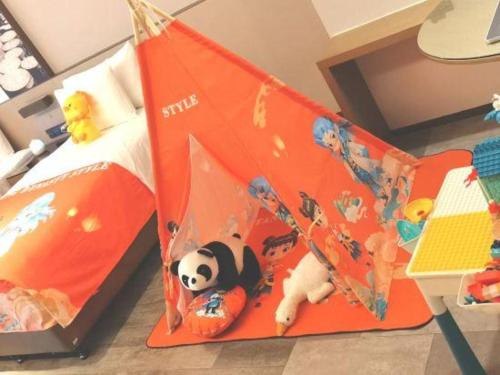 a childs bedroom with an orange bed with a panda bear on it at Wanda JIN Baise in Baise