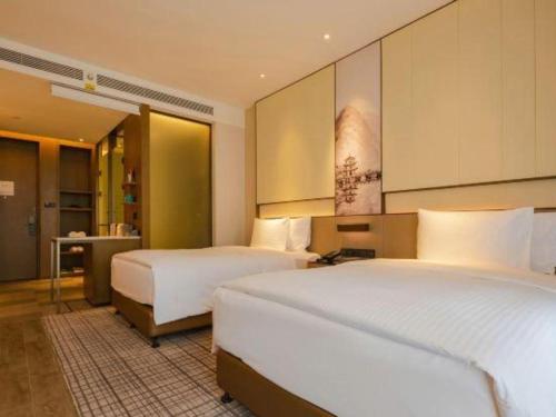 a hotel room with two beds and a bathroom at Wanda JIN Baise in Baise