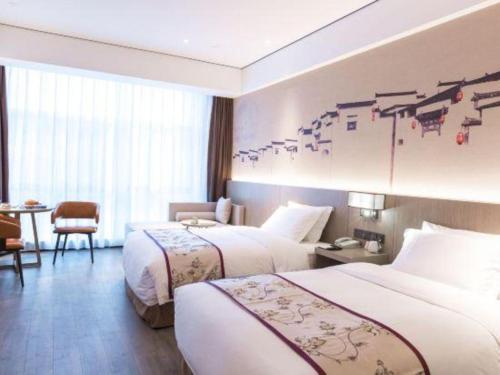 a hotel room with two beds and a table at GRACE Select Hotel (Kunshan Huaqiao International Convention Center) in Suzhou