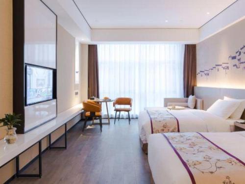 a hotel room with two beds and a flat screen tv at GRACE Select Hotel (Kunshan Huaqiao International Convention Center) in Suzhou