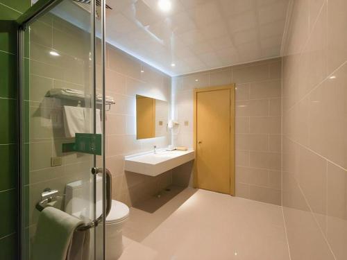 a bathroom with a shower and a toilet and a sink at GreenTree Inn Qinhuangdao Changli County Guangyuan Life Square Duanyang Street East Section in Qinhuangdao