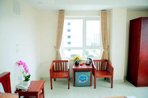 a living room with a table and two chairs and a window at Hotel Thanh loi in Mỹ Ðuc