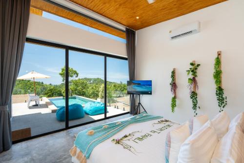 a bedroom with a large window and a swimming pool at Pahili Pool Villas Koh Phangan in Mae Haad