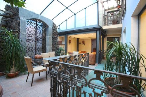 a balcony with a glass table and some plants at Rigel Hotel in Catania