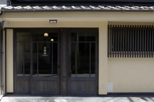 a building with a pair of doors on it at Machiya-Hotel Kyoto-ba 町屋ホテル 京都宿 in Kyoto