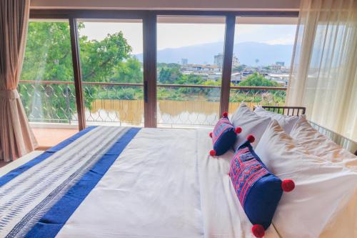 a bed in a room with a large window at S48 River Ping in Chiang Mai