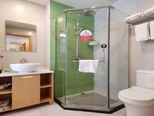 a bathroom with a glass shower and a sink at GreenTree Inn Guiyang Wudang District High-speed Railway East Station in Jinzhuzhen
