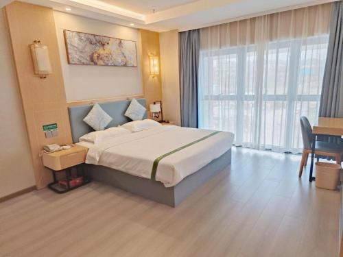 a hotel room with a large bed and a window at GreenTree Inn Guiyang Wudang District High-speed Railway East Station in Jinzhuzhen