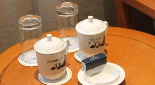a table with two cups and saucers on it at Xiamen Airlines Quanzhou Hotel in Quanzhou