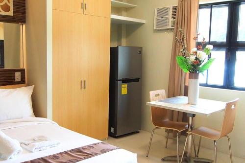 Cette chambre comprend un lit, une table et un réfrigérateur. dans l'établissement Marton Suites, à Sanghay