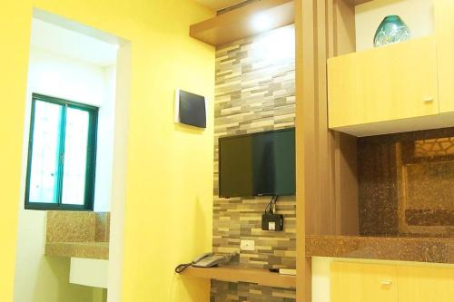 une pièce avec une télévision à écran plat sur un mur dans l'établissement Marton Suites, à Sanghay