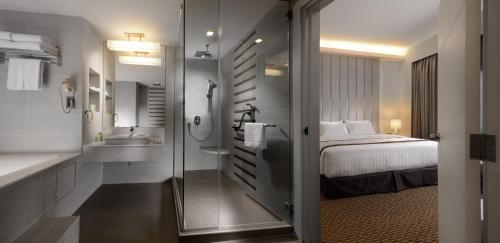 a bathroom with a bed and a tub and a sink at Sunway Hotel Georgetown Penang in George Town