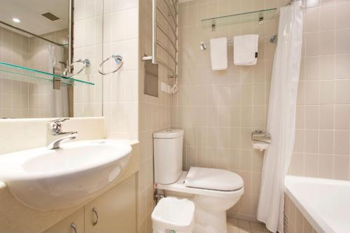 a white bathroom with a sink and a toilet at Lantern 13 - Deluxe Terrace in Thredbo