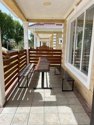 a patio with two benches and a table on a porch at Ne Dacha in Karakol