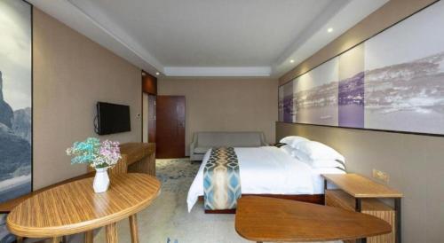 a hotel room with a bed and two tables at Guilin Manhatton Hotel Tianjie in Guilin