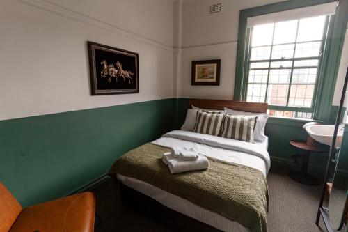 a bedroom with a bed and a sink in it at Courthouse Hotel in Sydney