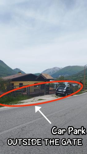 a car park outside the gate with a car parked at Villa Ola in Barrea