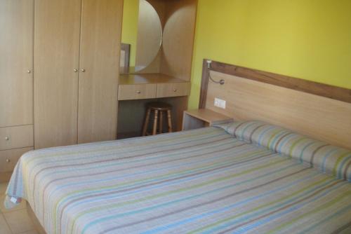 sypialnia z łóżkiem z paskiem w obiekcie Navarone Beach Apartments w mieście Petrokhorion