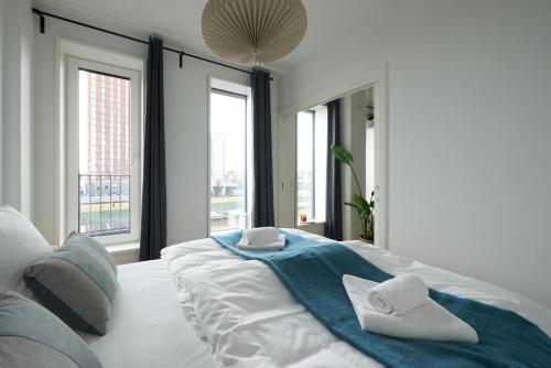 a white bedroom with a bed with towels on it at Elegant Cozy Modern Free Parking in Copenhagen