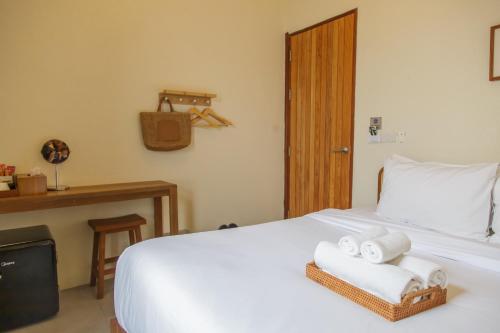 a bedroom with a bed with towels on it at Mamori House at Kohlarn in Ko Larn