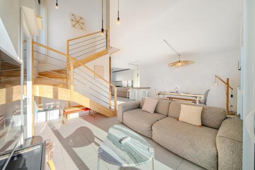 un salon avec un canapé et un escalier dans l'établissement Skyview 360 - Rooftop - 3 Terrasses - Parking - Climatisation, à Saint-Jean-de-Védas