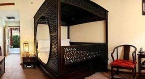 a large wooden bed with a large mirror in a room at Lijiang Liwang Hotel in Lijiang