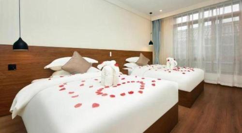 a bedroom with two beds with red roses on them at Lijiang Liwang Hotel in Lijiang