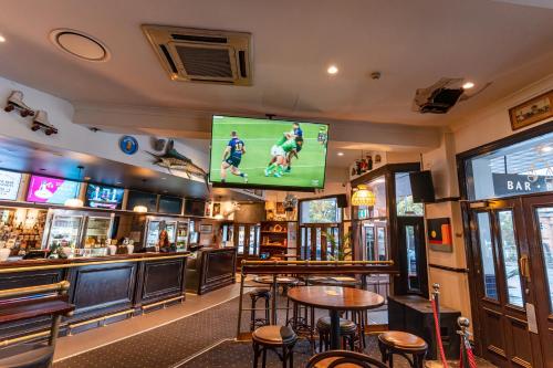 a bar with a large screen in a pub at Courthouse Hotel in Sydney