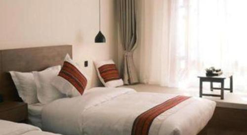 a bedroom with a bed and a window at Lijiang Liwang Hotel in Lijiang