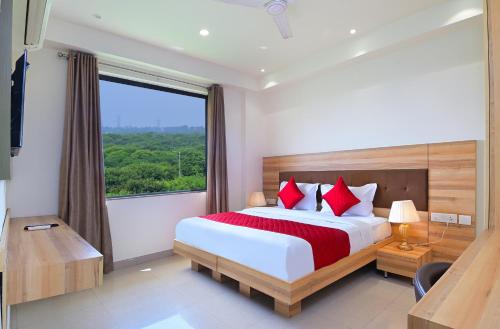 a bedroom with a large bed and a large window at My hotel Sector 23 Near Yashobhoomi Dwarka in New Delhi
