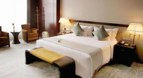 a large white bed in a hotel room at Weida Hotel Jinhua in Jinhua