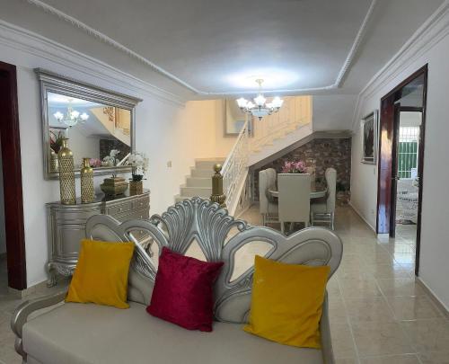- un salon avec un canapé blanc et des oreillers colorés dans l'établissement Casa de tres habitaciones con piscina, à La Romana