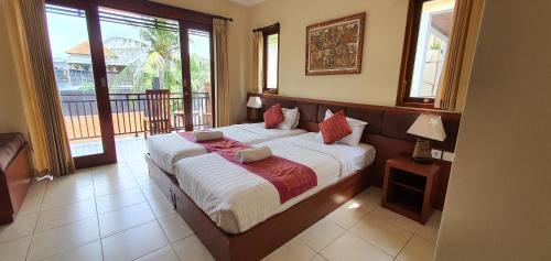 a bedroom with a large bed and a balcony at Buah Nagasari Ubud Villa in Ubud