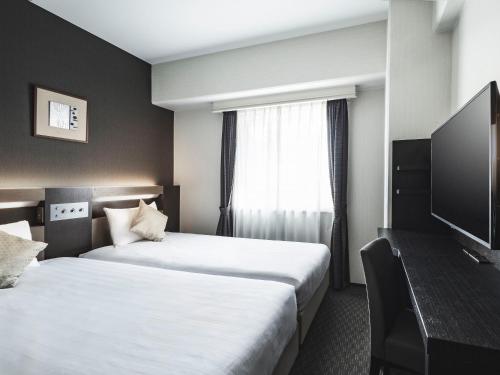a hotel room with two beds and a window at Hotel New Hankyu Osaka Annex in Osaka