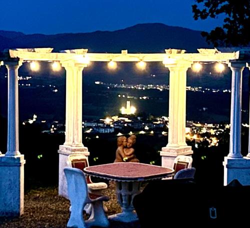 a teddy bear sitting at a table on a pergola at night at Poggelleri la cartolina su Poppi e le colline toscane in Poppi
