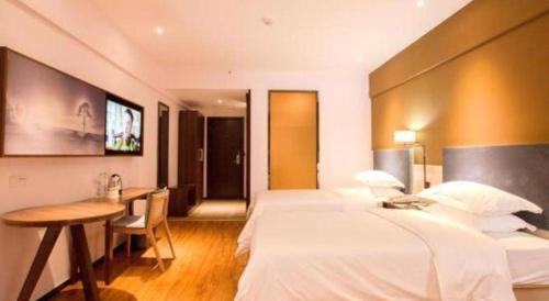 a hotel room with two beds and a desk at JTOUR Inn Guilin Two Rivers and Four Lakes Walmart in Guilin